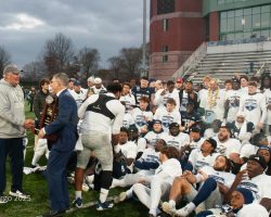 Coach Flemming gets congratulated by the ACC Commissioner and receives the CAA championship trophy