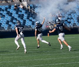 Ty Goff splits the uprights with 15 seconds remaining as the Bristol Train of Artillery's cannon smoke fills the air, sealing a URI victory over Brown. Number 45 and his teammates celebrate what would prove to be the game-winning field goal at Centreville Bank Stadium in Pawtucket