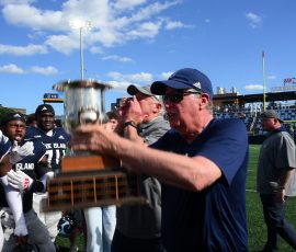 Rhode Island Governor Dan McKee presents the Governor's Cup to the URI Rams following their dramatic last-second victory over Brown University